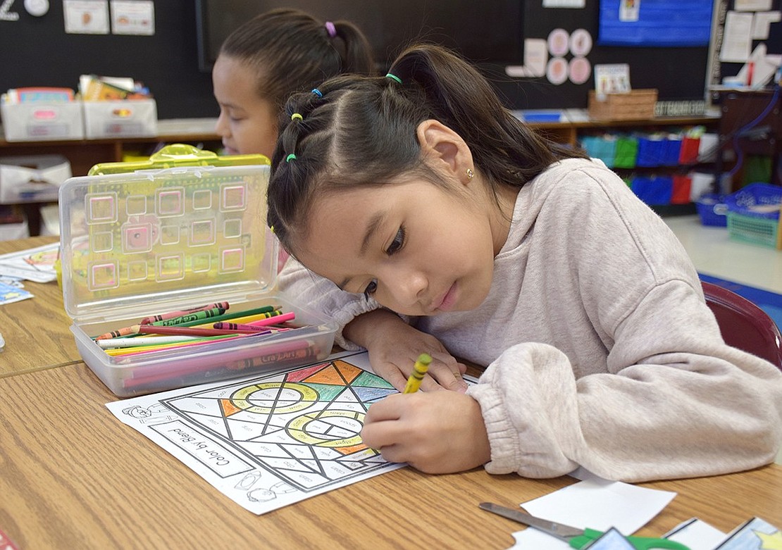 Madeline Marroquin, a first-grade dual language student in Lidette Hernandez’s classroom, invests herself in a coloring activity themed around the number 100.