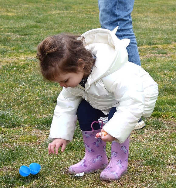 After having emptied an egg of its sweet treasure, 2-year-old Rye Brook resident Skylar Chalfen responsibly bends down to pick up the blue vessel.