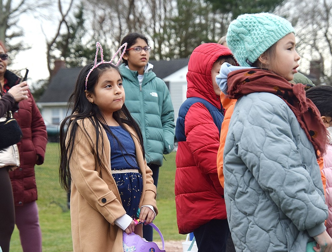 Port Chester 7-year-old Kenya Nieves, who lives on Franklin Street, stands attentive as she listens to the rules for the Easter Egg Hunt.