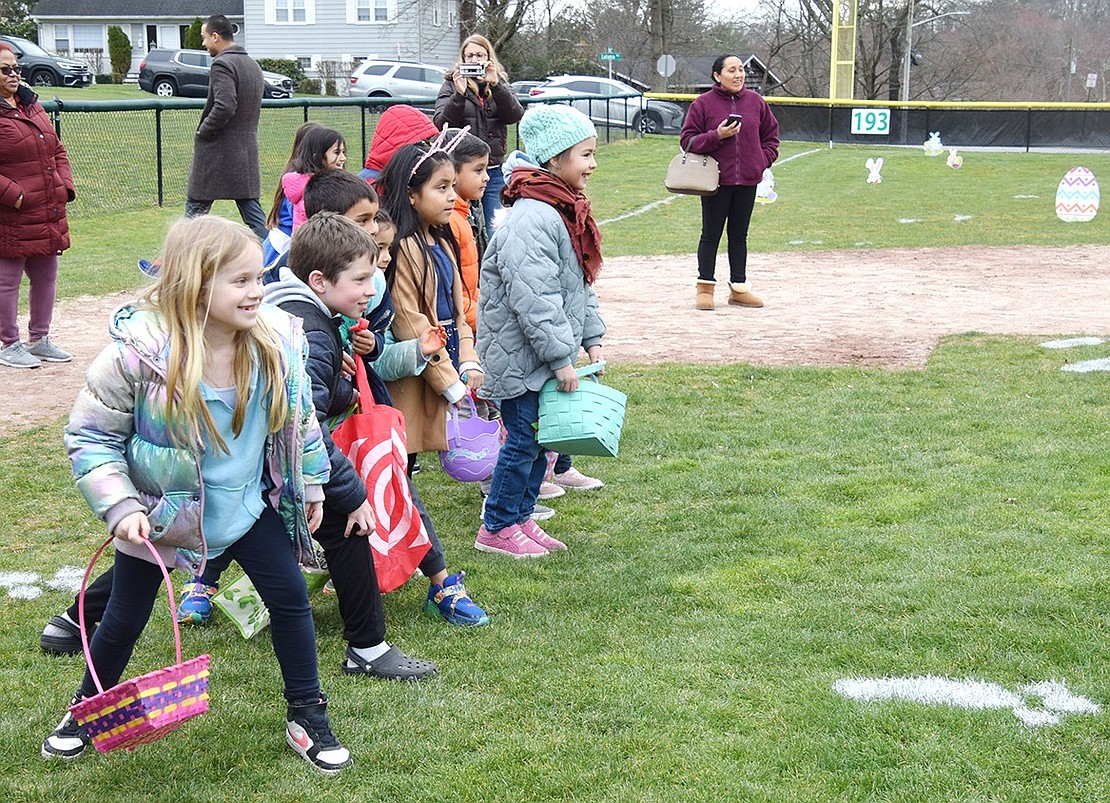 A dozen kids, including Talcott Road resident Linden Fields (left), a second-grader at Ridge Street Elementary School, get ready to make a mad dash for treats during the Rye Brook Recreation Department’s second annual Easter Egg Hunt on Tuesday, Mar. 26. The Pine Ridge Park baseball field was filled with holiday-themed surprises for the children to find on the chilly afternoon.