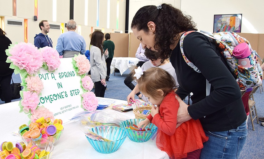 Holly Lane resident Elisha Heaps helps her 2-year-old daughter Danielle put together a hospital activity bag at Congregation KTI’s Mitzvah Day celebration on Sunday, Apr. 7. The event, organized by Stacie Schinfeld, Hope Grider and Rabbi Ben Goldberg, brought families to the synagogue to design placemats, write letters and more to make a difference in people’s lives through good deeds.