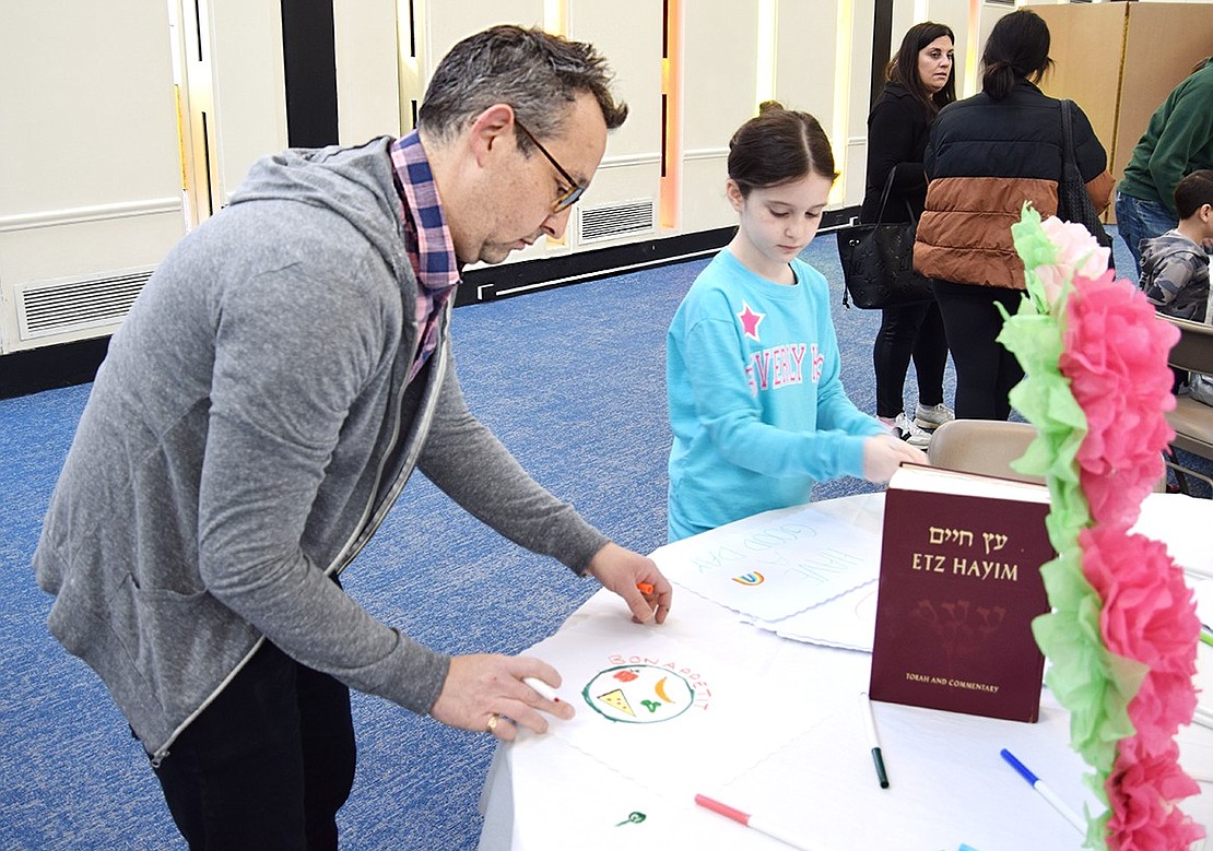 Old Orchard Road resident Eric Schinfeld admires the placemat he’s working on alongside his 10-year-old daughter Sophie.