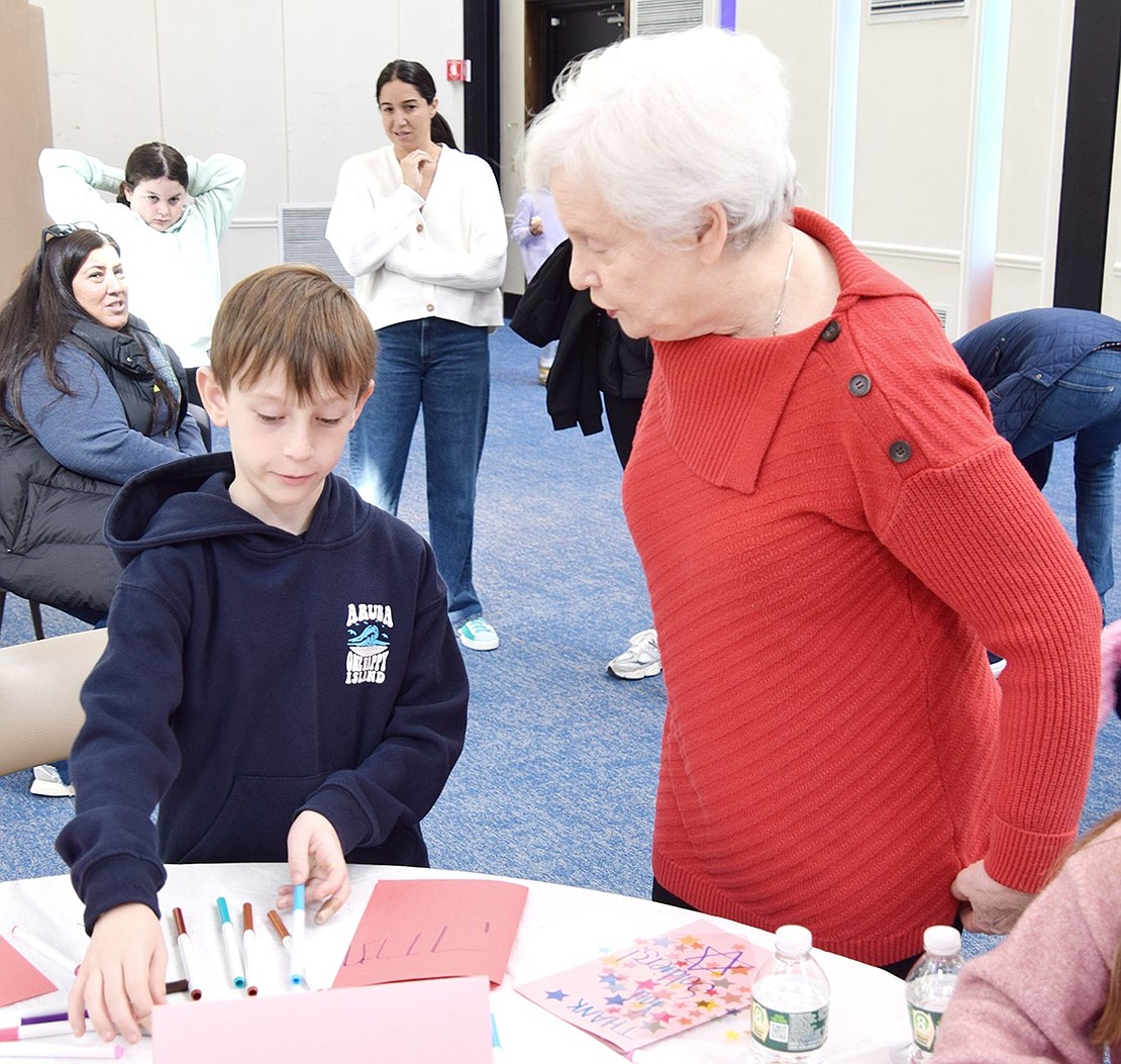 Jaxon Hudesman, a second-grader at Ridge Street School, crafts a card supporting Israeli soldiers with some input from his grandmother, Davida Scher.