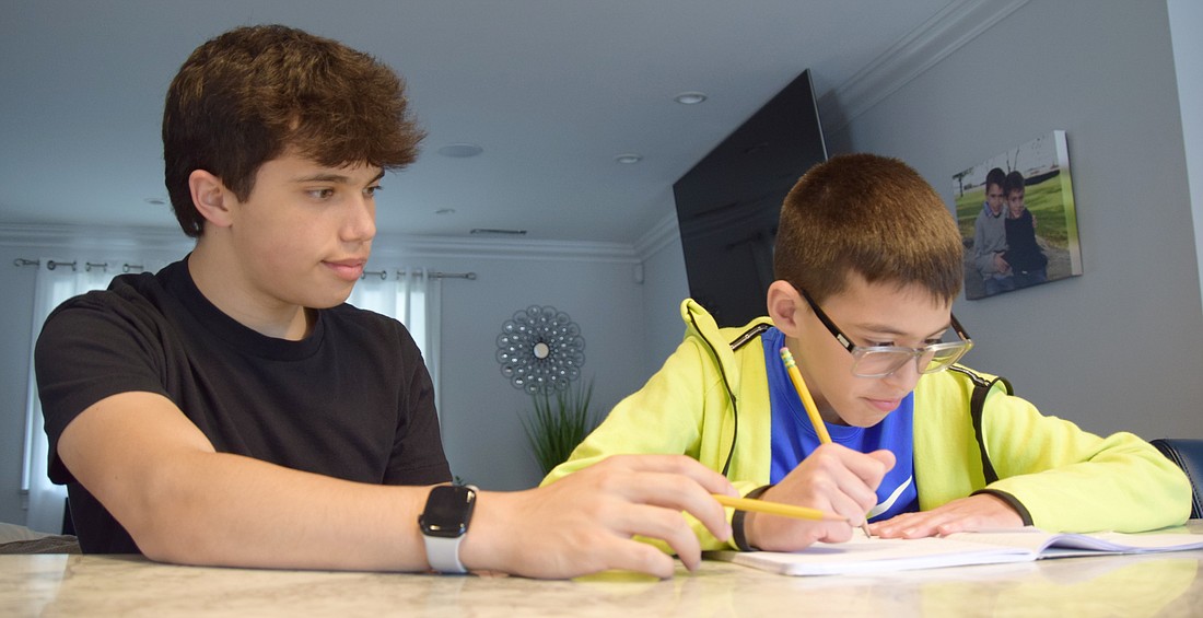 Blind Brook High School sophomore Austin Frankel (left) gives Ridge Street Elementary School fourth-grader Christopher Conte some spelling tips during their hour-long tutoring session in the Conte home on Rock Ridge Drive on Monday, Apr. 8. They’re members of the student-run Homework Helpers afterschool program, which brings older students to the homes of elementary schoolers to provide academic support.