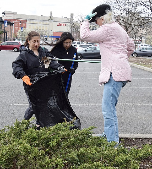 Holding onto her hat on this windy day, Julie Chateauvert of 360 Westchester Ave. picks up trash from an island in the Port Chester Marina Parking Lot on Abendroth Avenue with a grabber and puts it into a waiting trash bag held by Glady Fernandez of Irving Avenue. She is accompanied by her daughter Jazlyn, 14, a member of Port Chester BSA Troop 420.