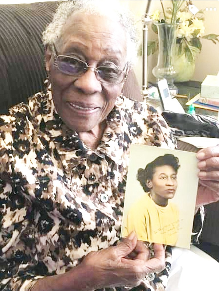 Orial A. Redd holds a photo of herself when she was a young woman.