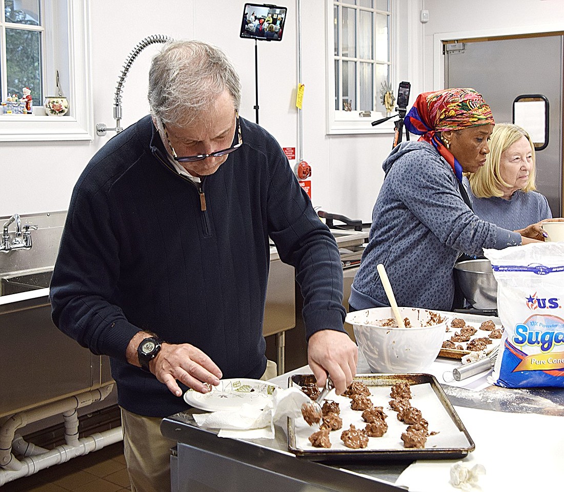 Longledge Drive resident Alan Lebowitz (left) carefully places scoops of chunky chocolate Passover cookies onto a baking tray as his friend Bola Ahmed and wife Lynn Lebowitz sift powdered sugar into a bowl. They’re participating in the first of four free cooking classes taught by professional chef Cara Tannenbaum on Wednesday, Apr. 17, hosted by the Town of Rye at Crawford Mansion Community Center.