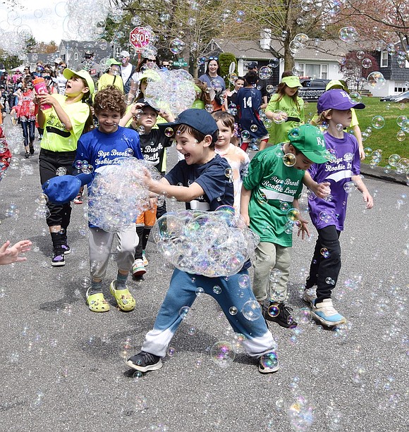 Members of the Rye Brook Rookie League and Little League animatedly play with bubbles during a parade on Saturday, Apr. 20. Children from every team marched from Ridge Street Elementary School to Pine Ridge Park to celebrate the commencement of the first ball game of the year during the Little League Parade hosted by Rye Brook Recreation.