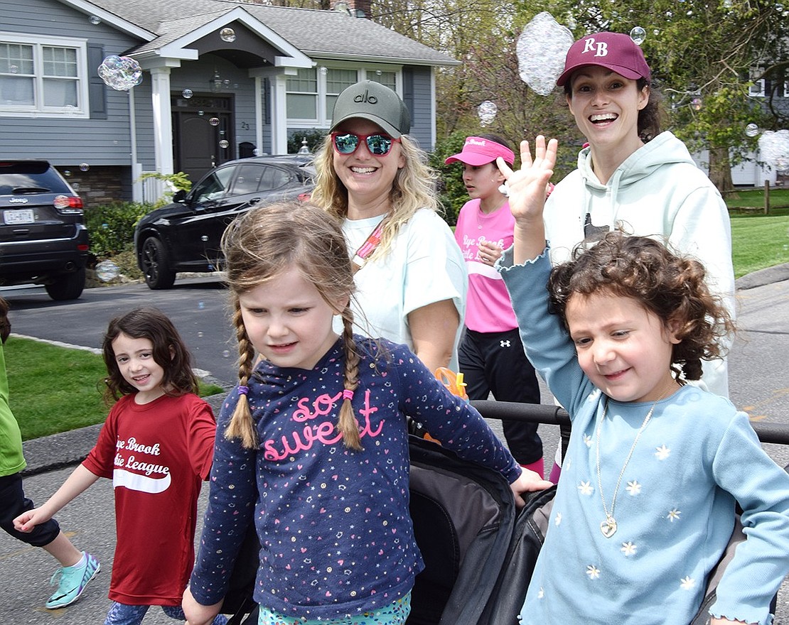 Noa Hoch (left), a 6-year-old resident of Old Orchard Road, walks alongside Rye Brook moms Kim Osterer and Haleigh Hoch. The Hoch matriarch is pushing 5-year-old Aria Tepper (left) and 4-year-old Evie Hoch in a stroller as they participate in the parade.