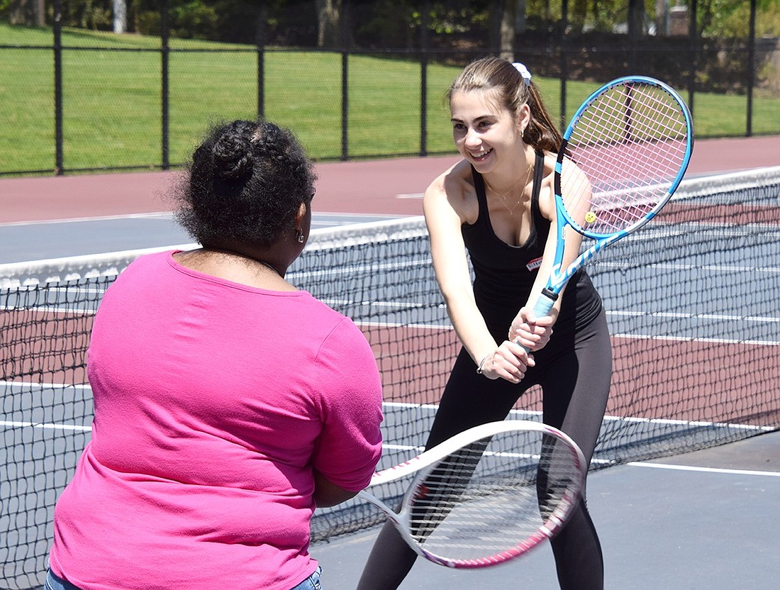 With a playful bounce and smile, Blind Brook High School junior Ella Mensch (right) teaches Dejahnae “Dee Dee” Ashman how to hold and swing a tennis racket on Wednesday, May 1. On early dismissal days at the school, Mensch volunteers by organizing activities with participants of The Arc Westchester, an agency providing support systems to individuals with developmental disabilities.