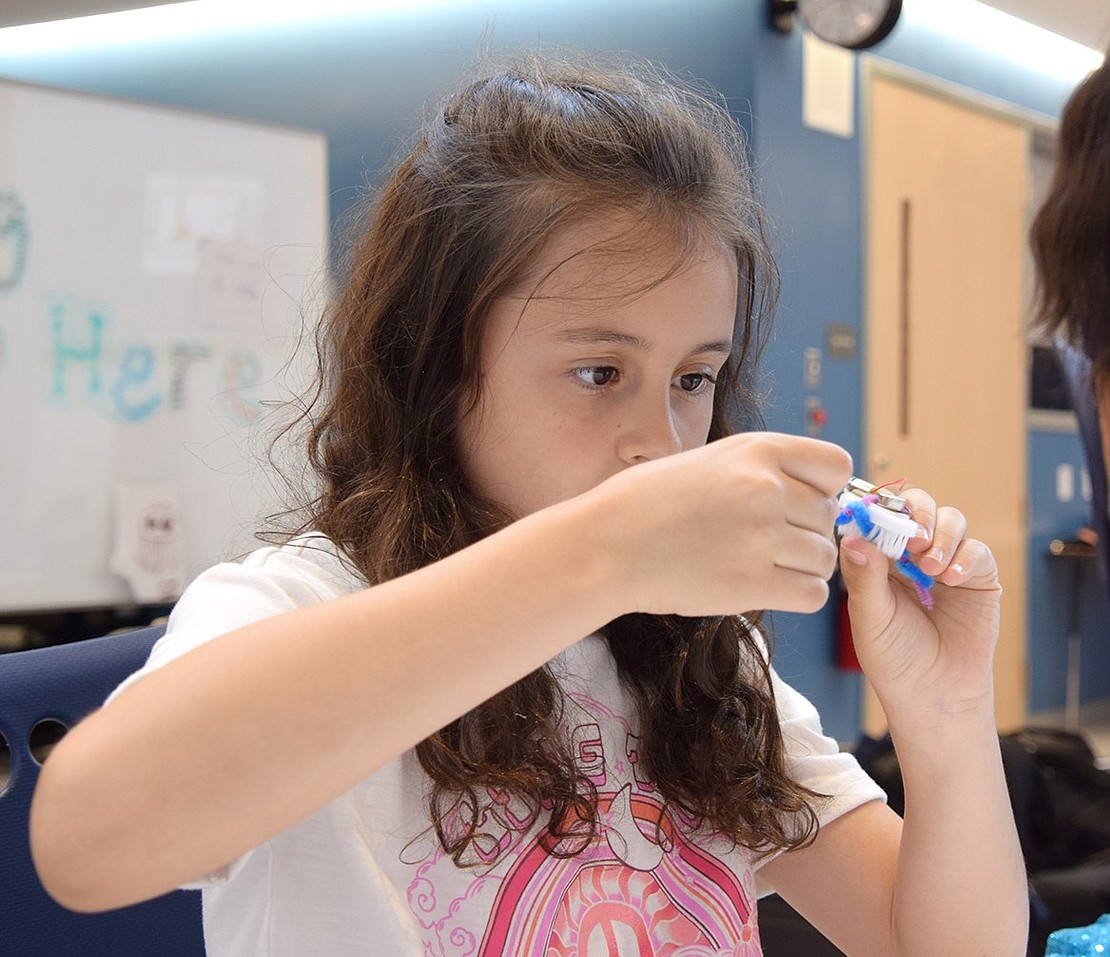 Ridge Street Elementary School fourth-grader Gabriella Kirby focuses as she meticulously assembles her BristleBot, which she named Bob, on the final day of the Junior Jellies Engineering program on Tuesday, May 14. The annual sessions for elementary schoolers are hosted by the Jellyfish, the Blind Brook High School robotics club team, and aim to foster an early interest in STEM.