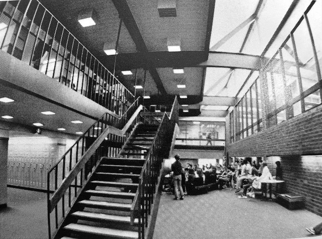 The original Commons at Blind Brook High School, opened in Fall 1973, had a suspended staircase, was surrounded by glass walls, and is pictured with dozens of students and faculty gathered.