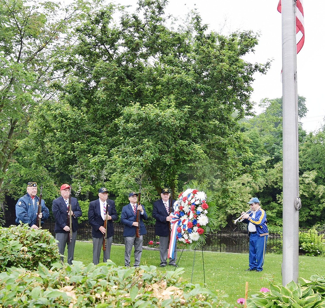 Members of the Port Chester American Legion Firing Team stand at attention while bugler Anthony Bubbico Jr. plays Taps at the William James Memorial dedicated to a wounded and now deceased World War II veteran adjacent to the Byram River near the Greenwich border on North Main Street.