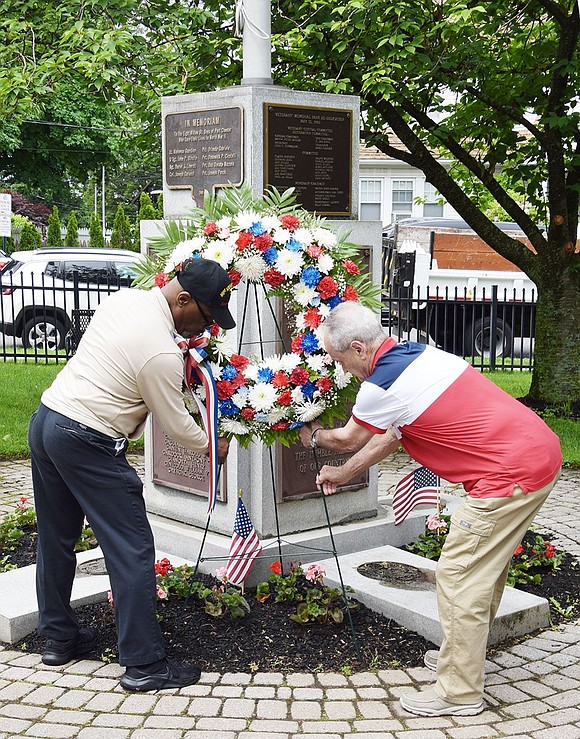 Vietnam veterans Jessie Harris of Port Chester and Steve Vespia of Rye Brook place a memorial wreath at the monument to Rye Town’s World War II and Korean War dead in Veterans’ Memorial Park at the corner of Westchester Avenue and North Regent Street during the final Memorial Day service on Monday, May 27.