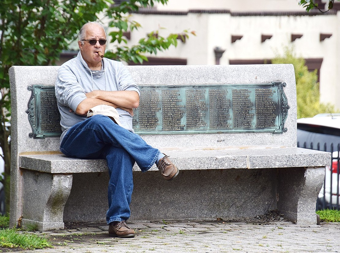 Port Chester Navy veteran Gary Stracuzzi observes the ceremony at Veterans’ Memorial Park from one of the benches listing the names of all Rye Town residents who served in World War I.