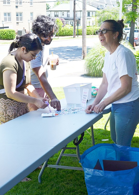 Therese and Matthew Cherian of Westchester Avenue, Port Chester, make peeps, small figures out of yarn, at a booth set up by Arianna Christopher (right) of the Port Chester Beautification Commission in front of the Carver Center at 400 Westchester Ave. She was also recruiting volunteers to participate in a Community Art Initiative.