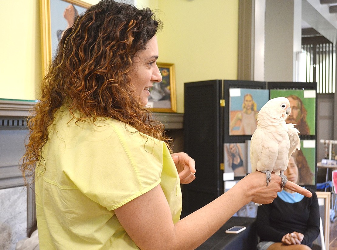 Exhibiting artist Helen Marder of Tamarack Road holds Elliot, one of two cockatoos Port Chester resident Eve Deitz and her husband brought to Crawford Mansion Community Center for the art show staged there as part of the second annual Port Chester Arts Festival throughout Port Chester and Rye Brook on Saturday, June 1. See additional photos on page 20.