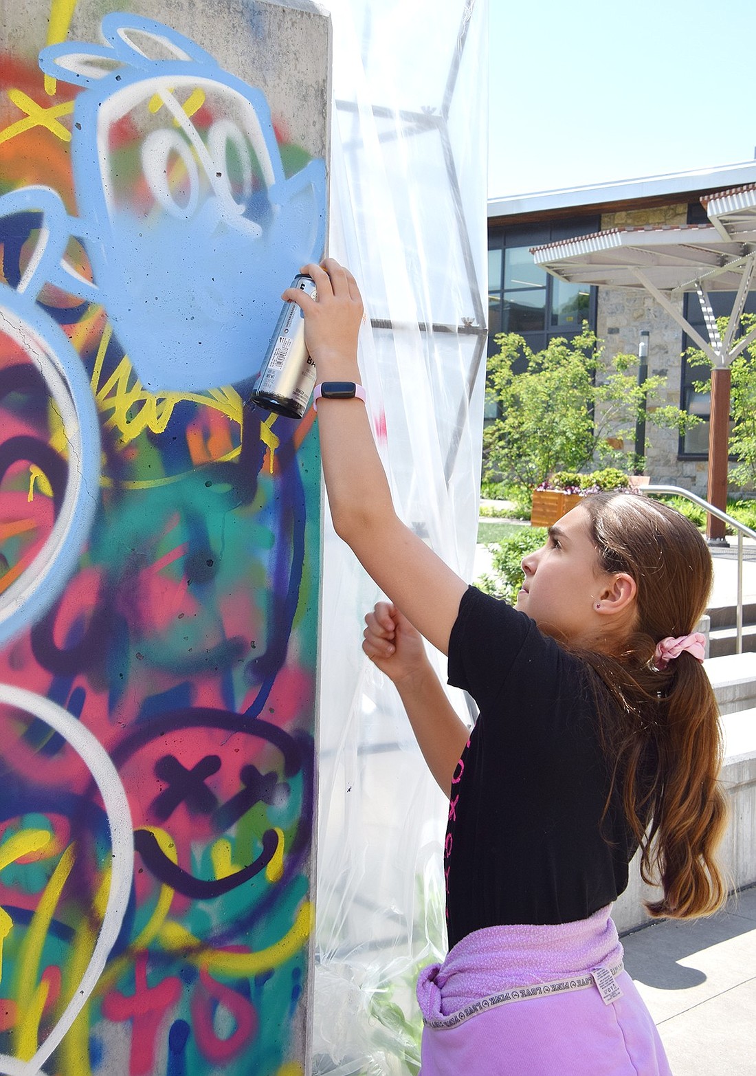 Ridge Street Elementary School fifth-grader Emily Rosen uses spray paint to fill in a bluebird on a new mural in the school’s courtyard on May 21. With guidance through the school’s Artist in Residency program, the entire fifth-grade class left their mark on the building while learning about the tact and style of street art.