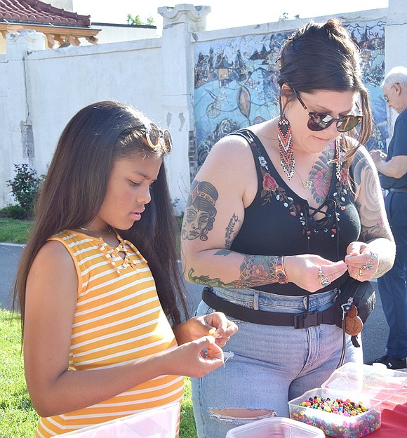 New residents of Port Chester Abby Walsh, 10, and her mother Rebekah make vibrant bracelets at one of the craft tables.