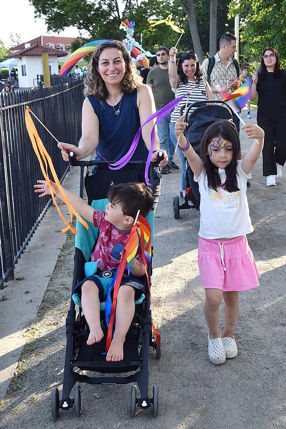 Rye resident Canan Gouchev pushes her 2-year-old son Constantine on the parade route as her 5-year-old daughter Juliette keeps pace alongside. Her wife, Jana, waves a streamer in the background while pushing their 10-month-old son Ani.