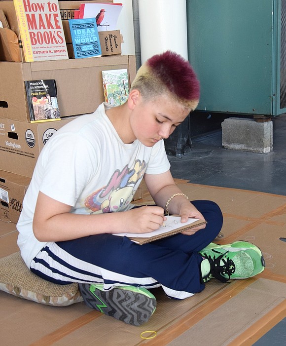 Elmsford resident Leonell Rothmaler, 12, sketches out a graffiti design after viewing the Neptune in June art exhibition at 33 New Broad St.