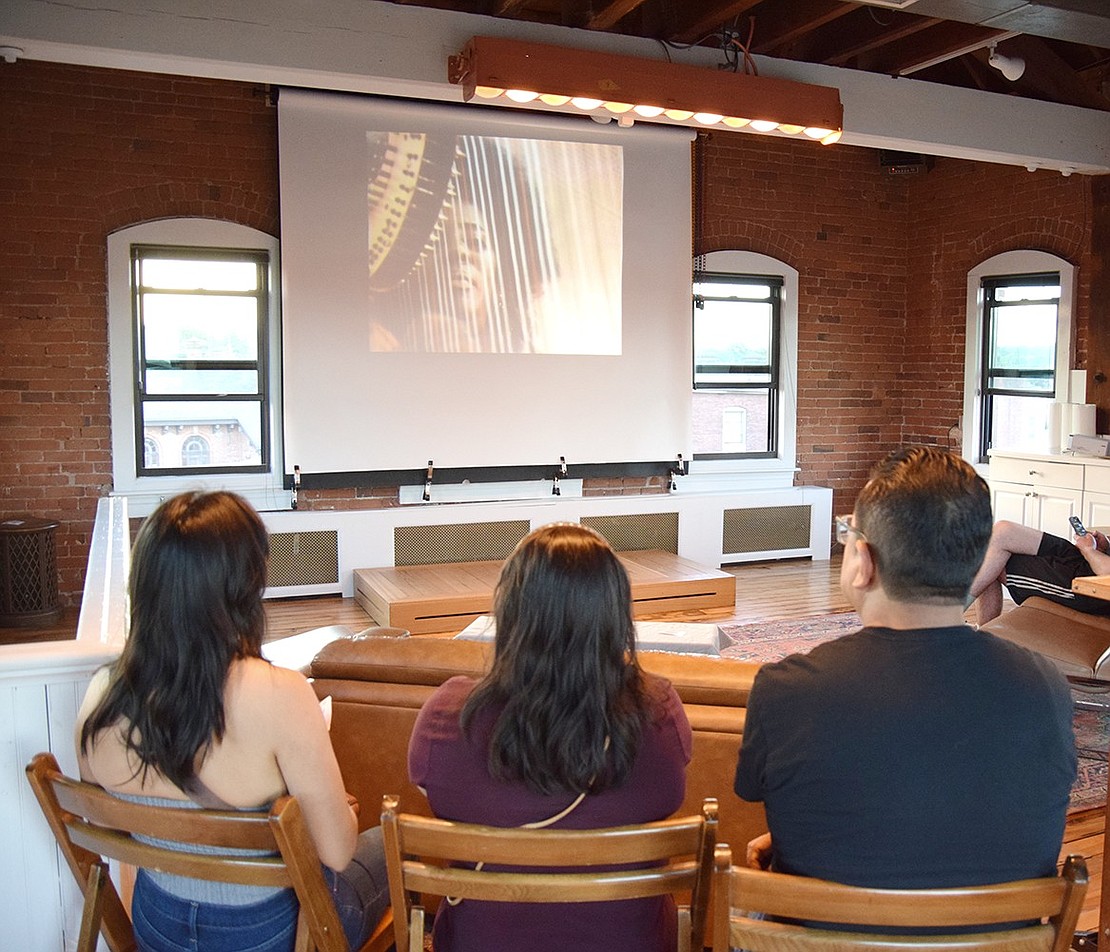 Grant Street residents Guadalupe (left), Delfina and Hector Conde watch a short film about American jazz musician Alice Coltrane being screened at Spank! Studios, located at the top of the Simons Building at 181 Westchester Ave.