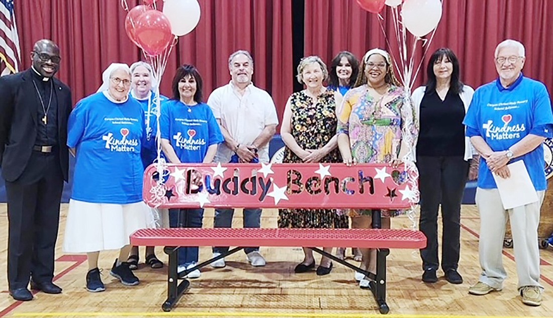 A Buddy Bench was dedicated at Corpus Christi Holy Rosary School on Wednesday, May 22. Attending the festivities were, from left, Father Deiunel, Sister Liz, Sister Karen, staff member Ginger Corbia, Mario DiGiorgio, a Bronx Kiwanis Club donor; County Legislator Nancy Barr, Principal Deidre McDermott, Christine Fils-Aime from State Senator Shelley Mayer’s office, staff member Pam Mickatavage and Tom Corbia from the Gil Gordon Anti-Bullying Committee. The celebration included T-shirts that say “Corpus Christi Holy Rosary School believes in Kindness” for all students and staff at a cost of $1,500. The bench cost $1,000. The shirts and bench were paid for by the Bronx Kiwanis Club, the Gil Gordon Anti-Bullying Committee in Port Chester and funds raised by the students.