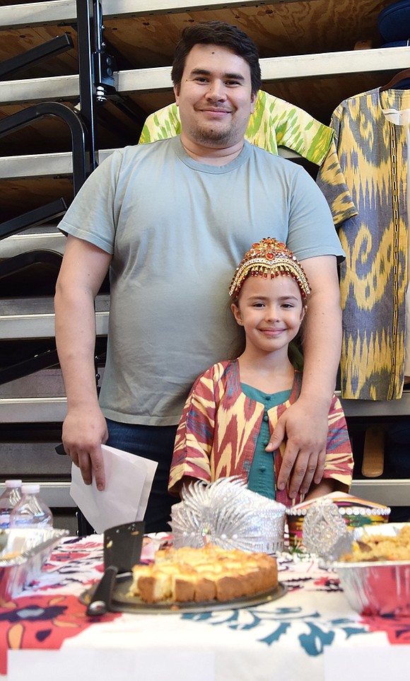 Representing Uzbekistan, Brush Hollow Crescent resident Askar Djabbarkhodjaev poses with his first-grade daughter Nicole, who is dressed in traditional clothing from her father’s homeland.