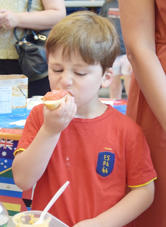 Kindergartner Martin Pulido takes a bite of Pan con Tomate, a traditional Spanish snack.