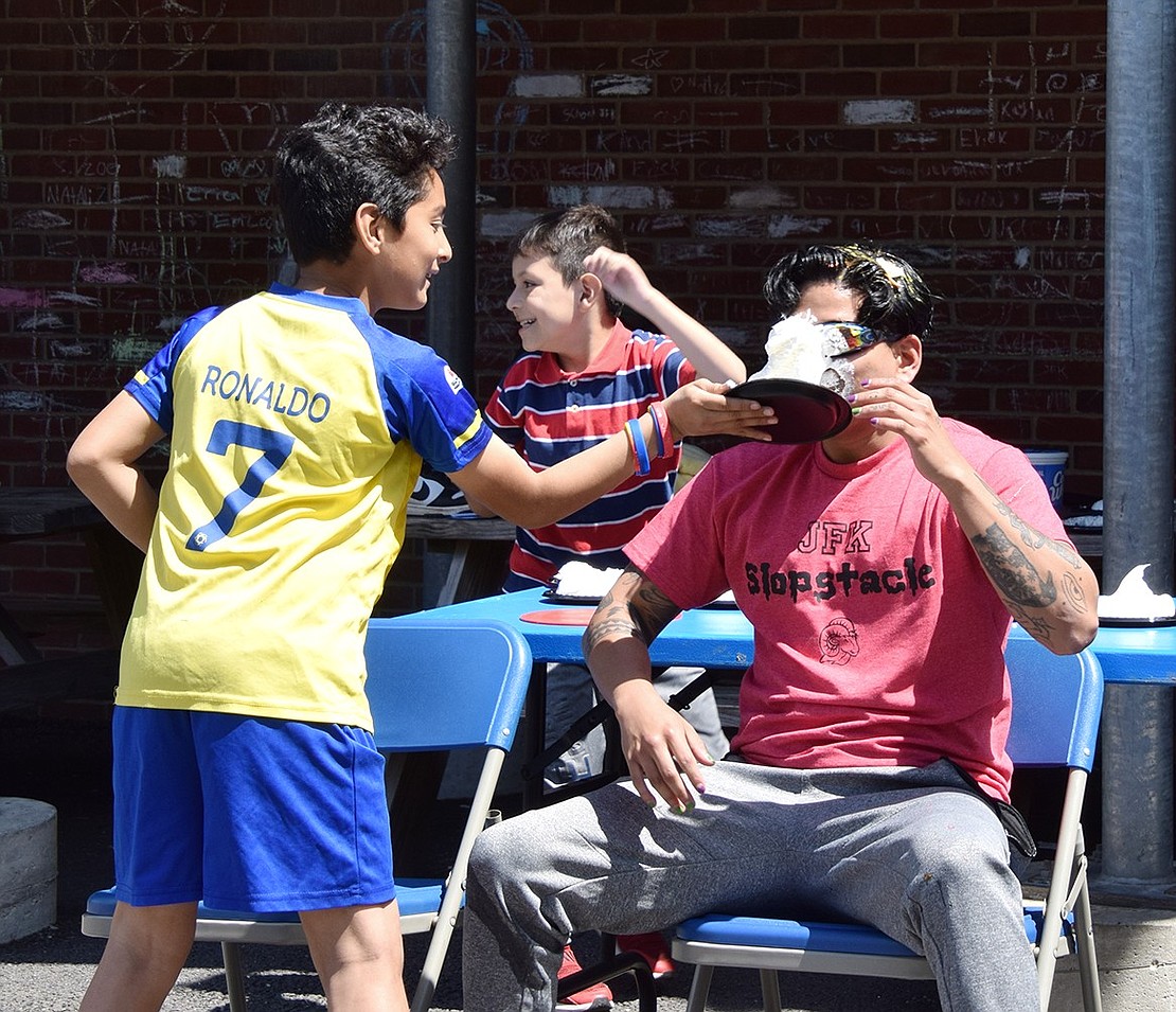 Third-grader Axel Rivera contributes to the mess by smearing a pie in the face of Randy Moran, a school psychologist.