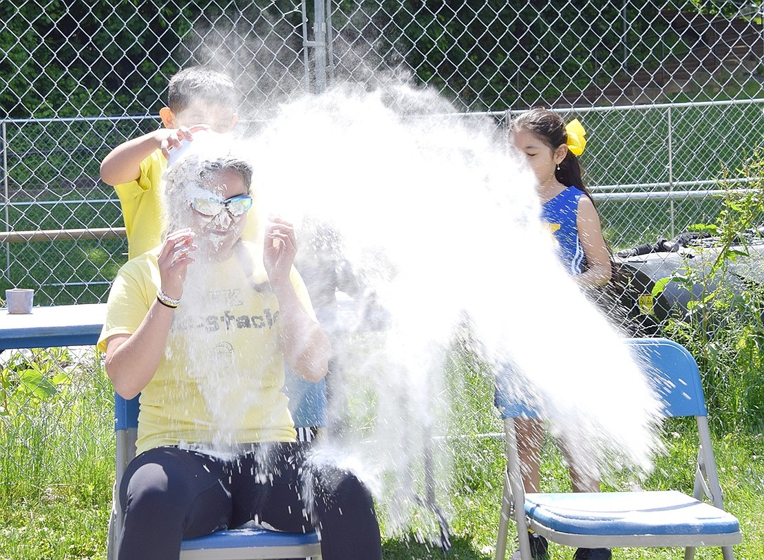 Brayan Chacon, a third-grader, drops a bowl of flour onto kindergarten teacher Danielle Salera.