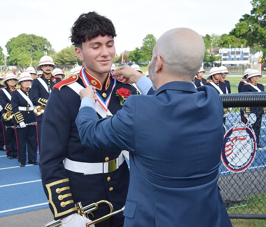 Christopher Gonzalez softly smiles at Band Director Mike Miceli after having been bestowed his medal, which was awarded to all graduating seniors that night.