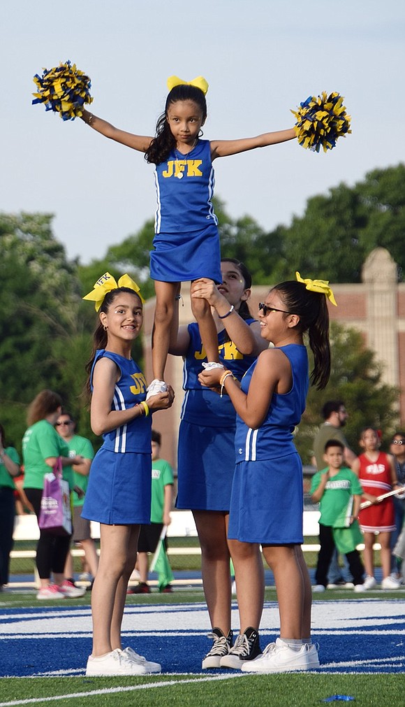 The John F. Kennedy School spirit squad shows off some classic stunt work. Fifth-graders Daisy Castillo (left), Hali Partida and Ariana Chunchi lift kindergartner Emily Ramirez above them for a pose.