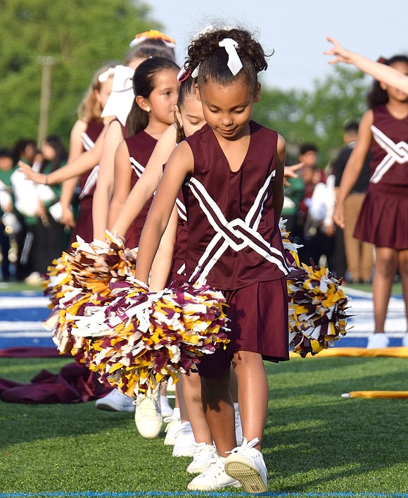 Focusing on the task ahead, King Street School first-grader Eliska Cadek grasps her pom-poms and prepares to bring spirit and energy to the field.