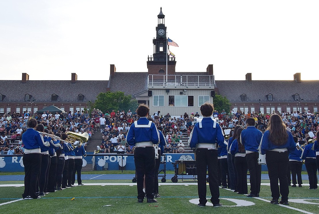 The Port Chester Middle School seventh-grade band plays to a cheering audience while gazing at the majestic high school which they’ll be attending in just a few years.