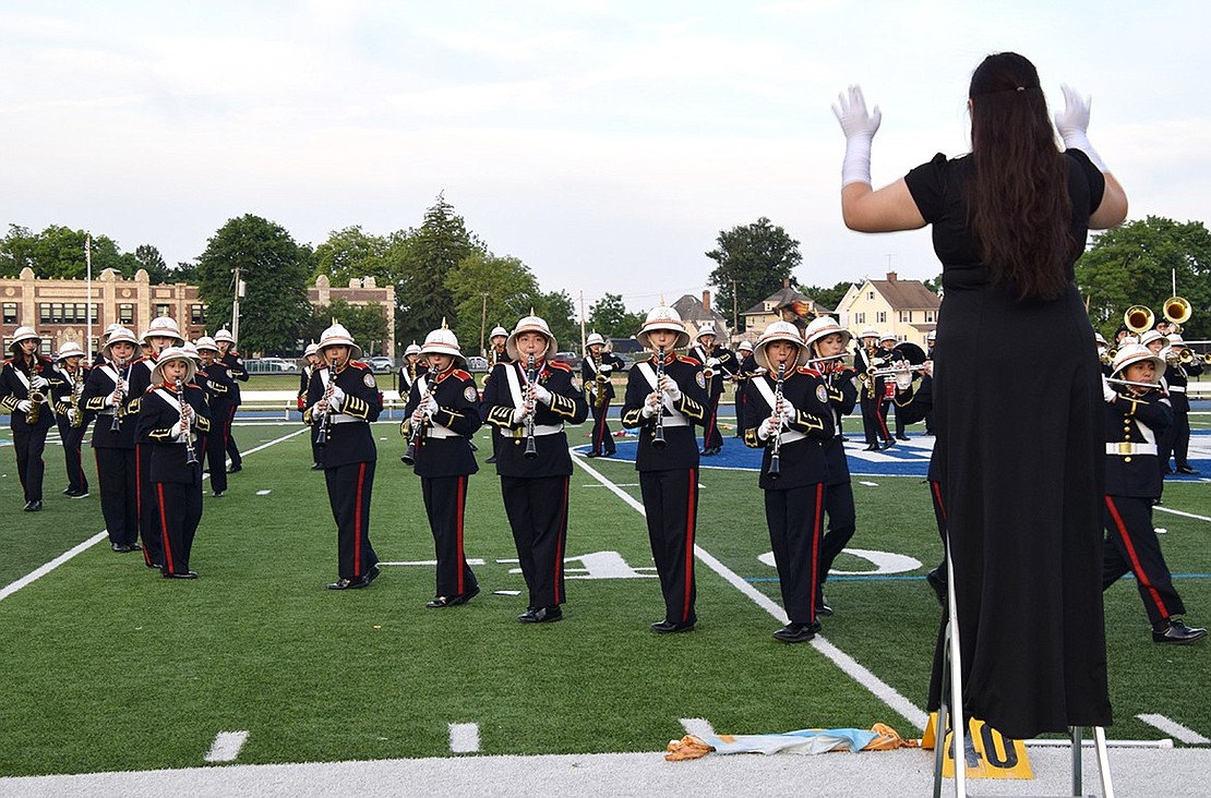 Sofia Coyt, a sophomore Pride of Port Chester drum major, conducts her fellow musicians as they go through their routine for the last time.