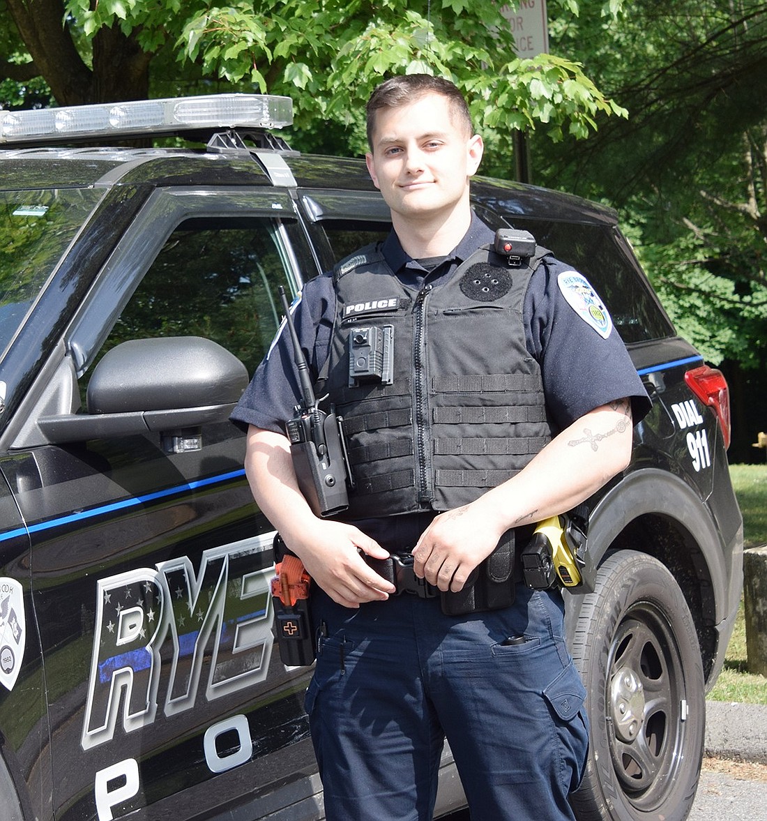The Rye Brook Police Department’s newest officer, Trevor Byrnes, poses next to his patrol car at 938 King St. on Wednesday, June 5.