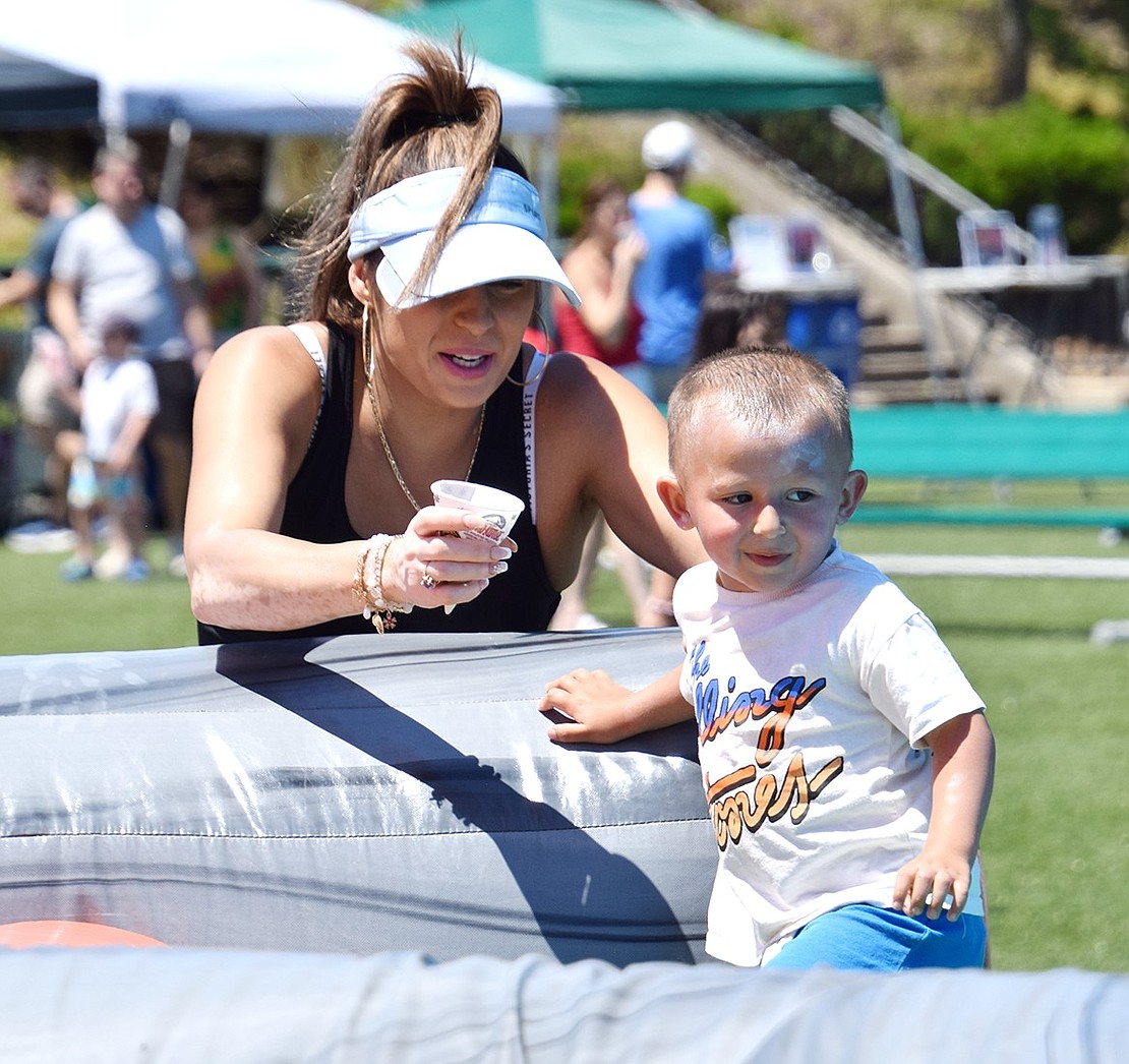 When the sun comes out, hydration is key. At the insistence of his mother Stephanie, Whittemore Place resident Thomas Morano, 2, takes a break from playing on an inflatable arena for a drink of water.