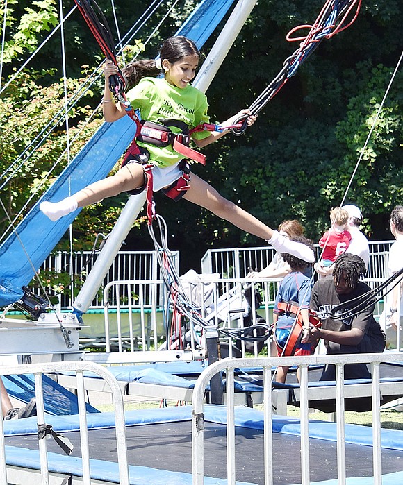 Showing off her acrobatic skills, Ridge Street School second-grader Nayali Dhamrhat can almost do a split while jumping on a trampoline bungee jumping attraction.