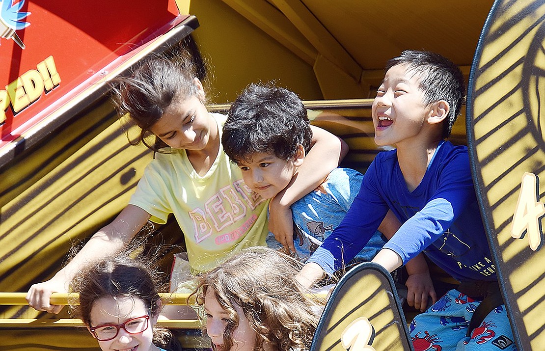 Though they express it differently, Rye Brook 8-year-old Inaayah Khan (left), her 2-year-old brother Jabir and Ridge Street School first-grader Connor Wu have a blast swinging on a boat ride. The trio are attending Rye Brook’s 42nd Birthday Party on Saturday, June 15, an annual event that took over a new location this year by setting up at the King Street athletic fields instead of Crawford Park.