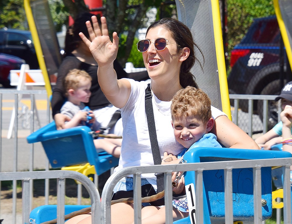 Birch Lane resident Emily Fink snuggles up with her 3-year-old son Daniel as she waves at loved ones watching them circle around on a swing ride at the Village of Rye Brook’s 42nd Birthday Party on Saturday, June 15.