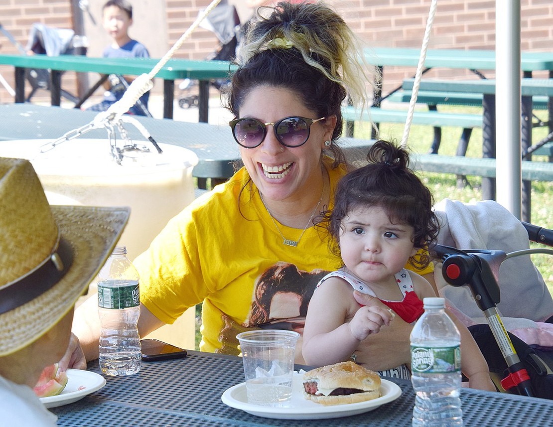 Beating the heat, Port Chester resident Melissa Pignatelli and her 1-year-old daughter Camila grab lunch and make new friends under a pop-up tent stationed at the top of the hill.