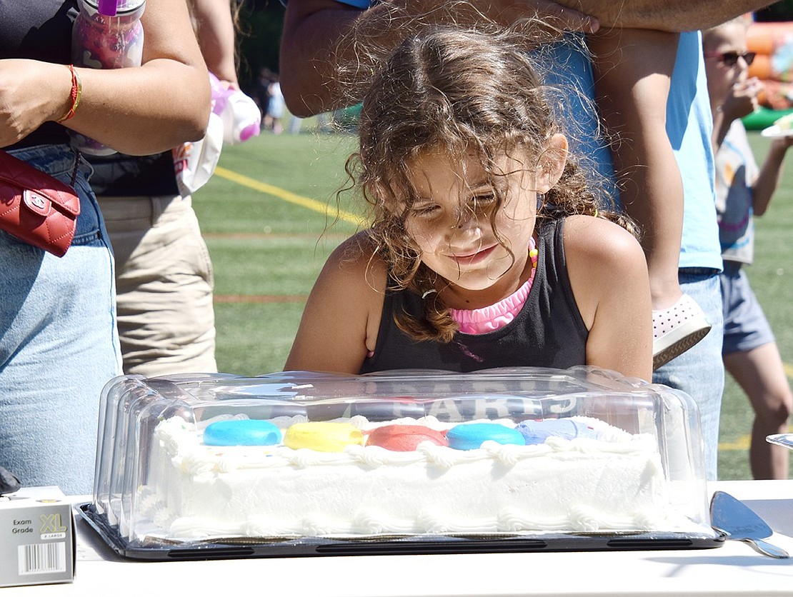 The birthday cake looks too good to resist—just ask Scarsdale 6-year-old Hannah Shabaj, who patiently waits to be served.