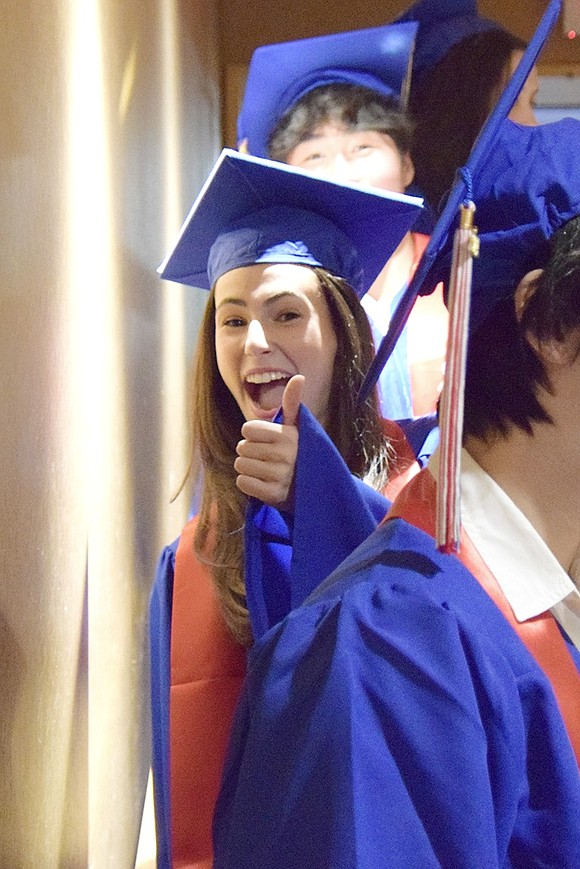 Before marching into the auditorium, Cassidy Wohl gives a thumbs up for good luck.