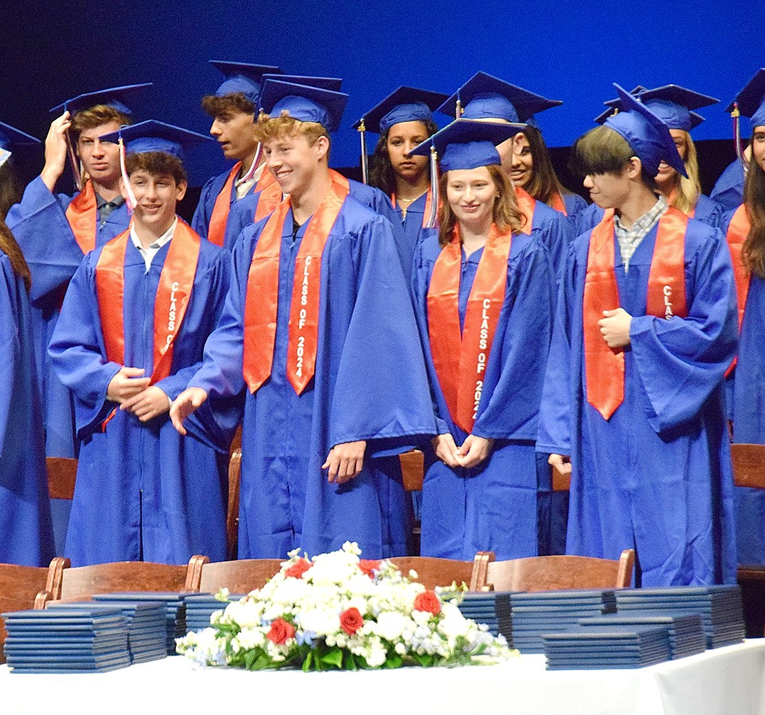 Evan Levitan (left), Seth Low, Laurel Lowenthal and Austin Lu file into their seats as “Pomp and Circumstance” plays, taking their first look at the diplomas they’re about to receive.