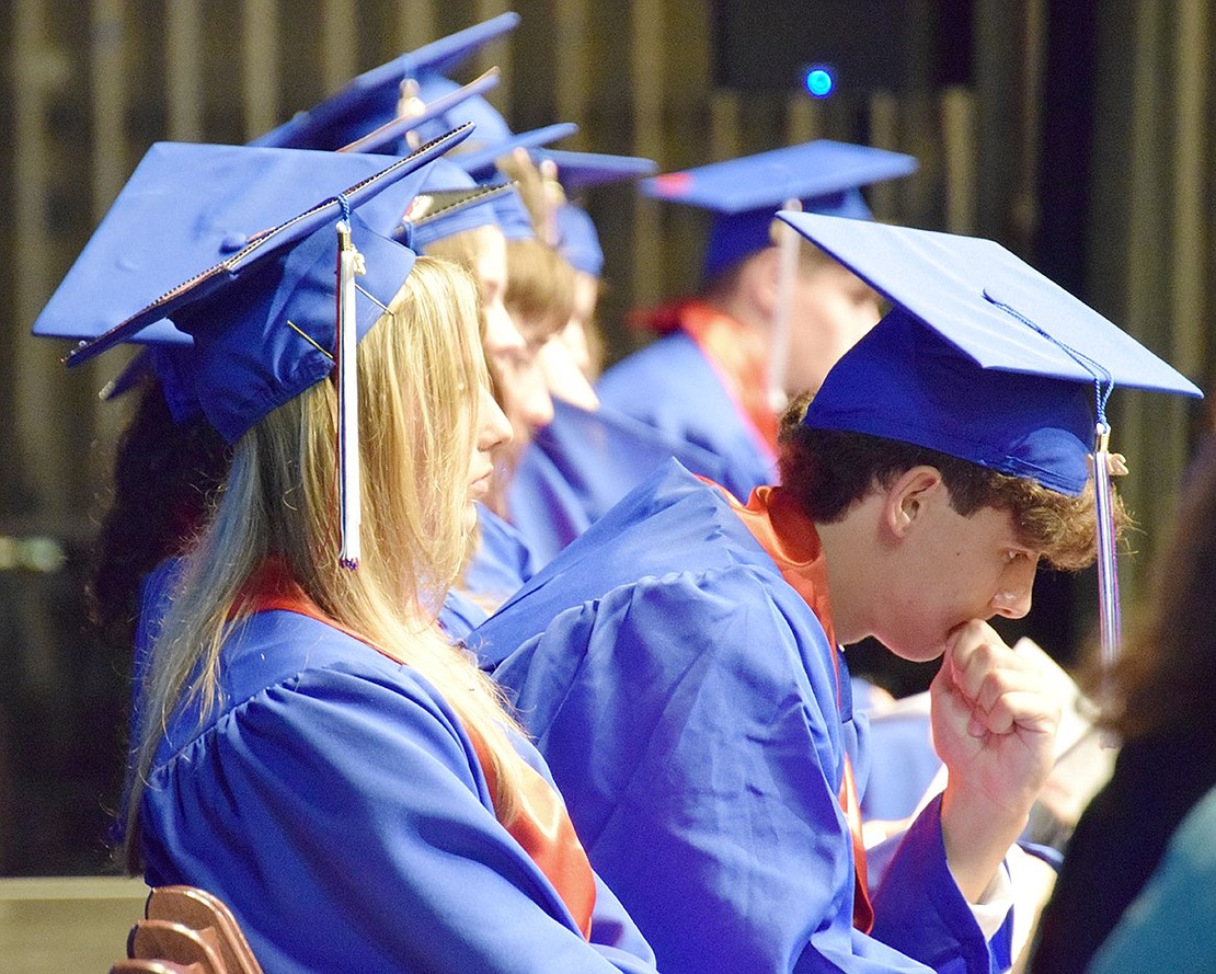 The whole world is ahead for Jordan Sternschein (front) and Ryan Stiler, who pensively listen to speeches from the back row on the stage.