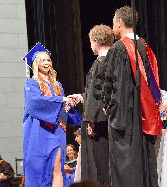 Jessie Kron eagerly marches across the stage to accept her graduation credentials and bid farewell to the Blind Brook Schools administration.