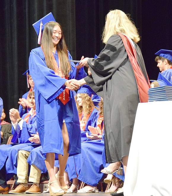 It’s nothing but smiles for Kyra Mak, as the crowd bursts into cheers when her name is called to collect her diploma from Principal Jennifer Chirles.