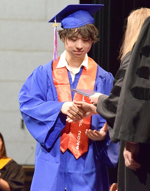 Politely and graciously, Derek Wang carries himself with pride as he shakes Principal Jennifer Chirles’s hand to accept his credential.