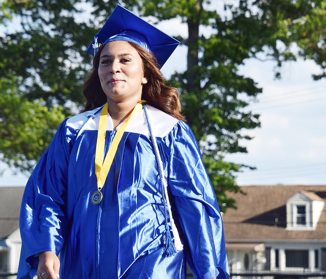 With confidence in her walk and pride radiating from her face, Yanairis Tejeda marches to her seat as “Pomp and Circumstance” welcomes graduates to the field.